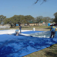 Lay out tarps to protect the tent top